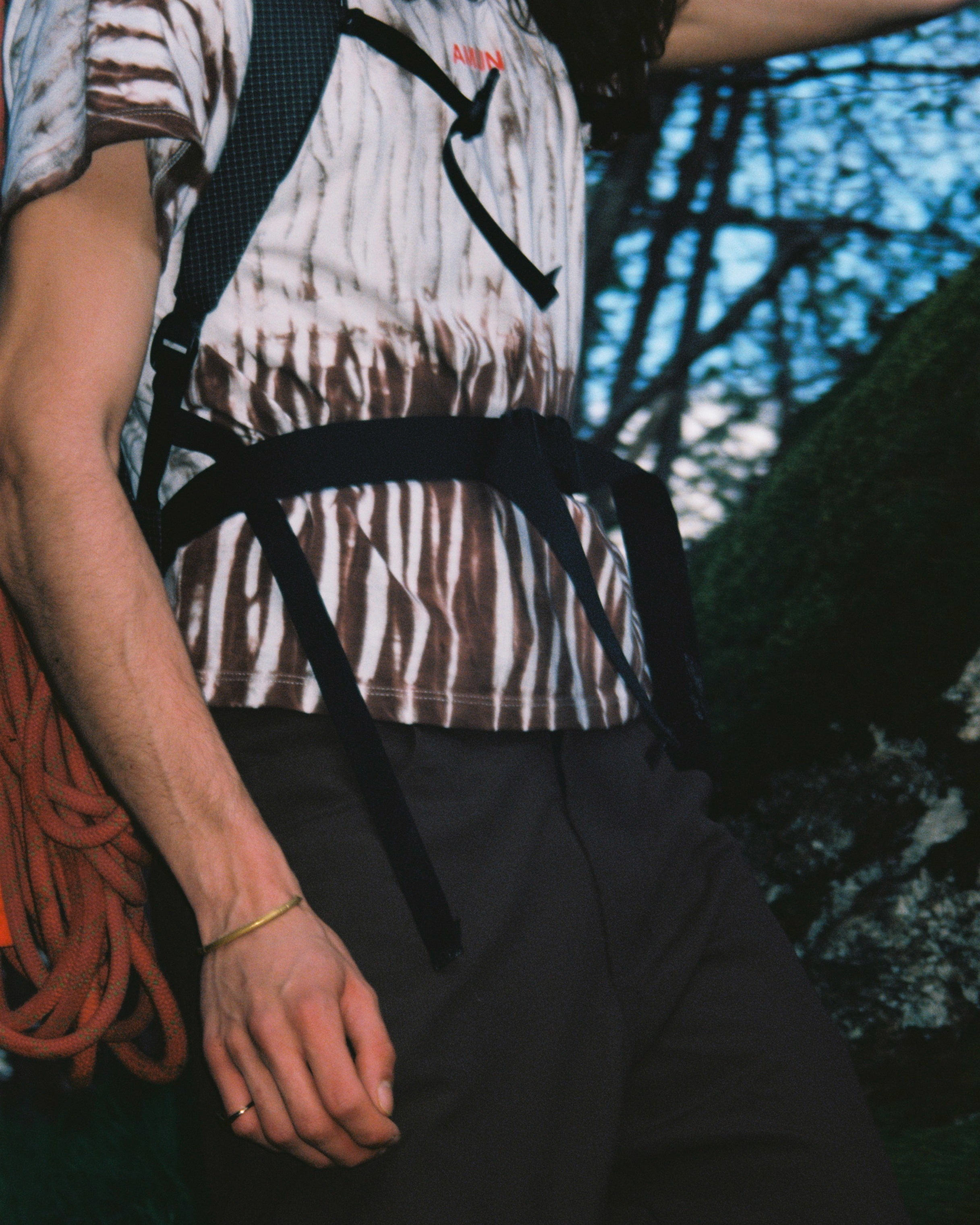 Person holding climbing ropes with a forest background