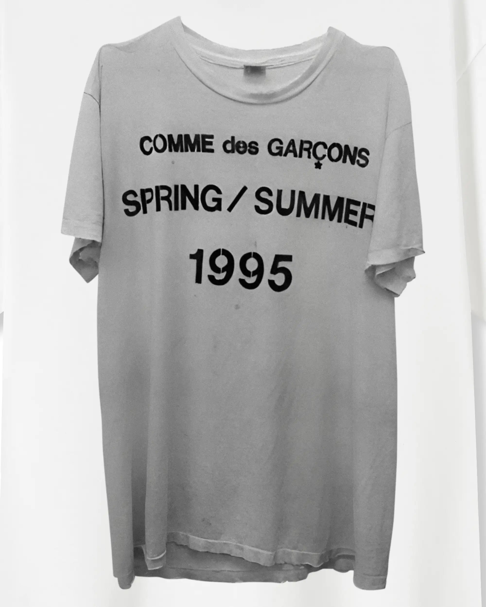Gray t-shirt with 'Comme des Garcons Spring/Summer 1995' text on a white background