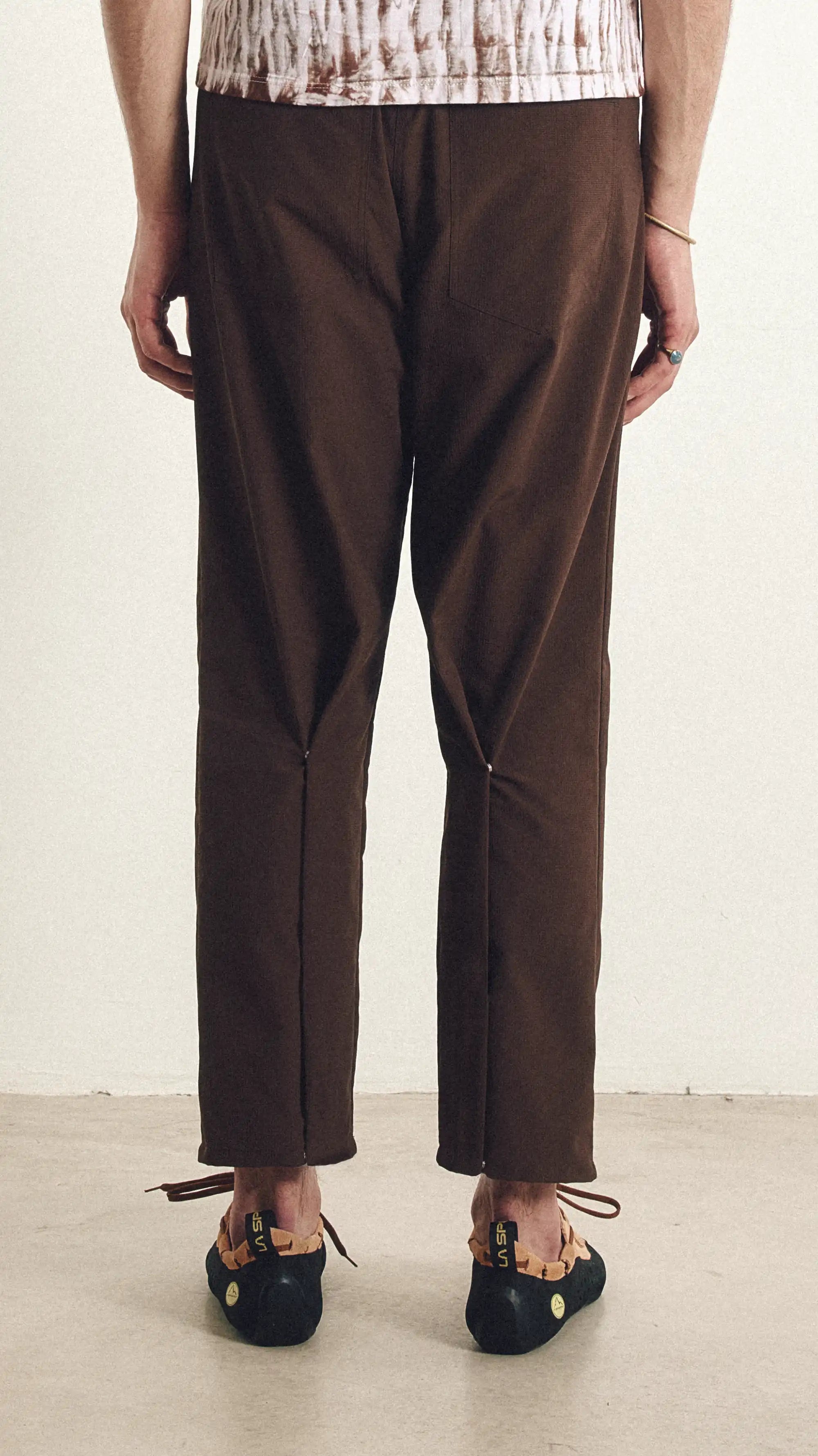 Brown pants worn by a person on a plain background