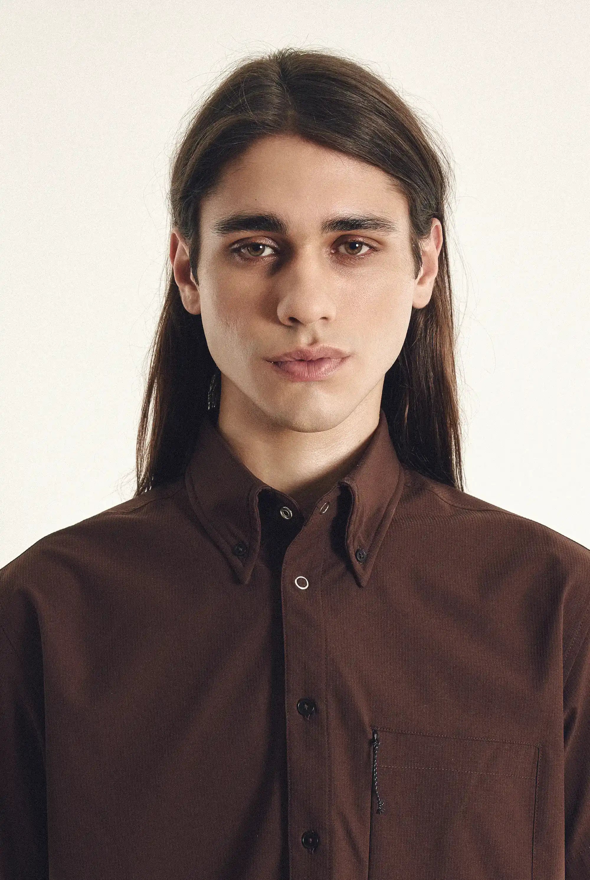 Man wearing a brown jacket against a plain background