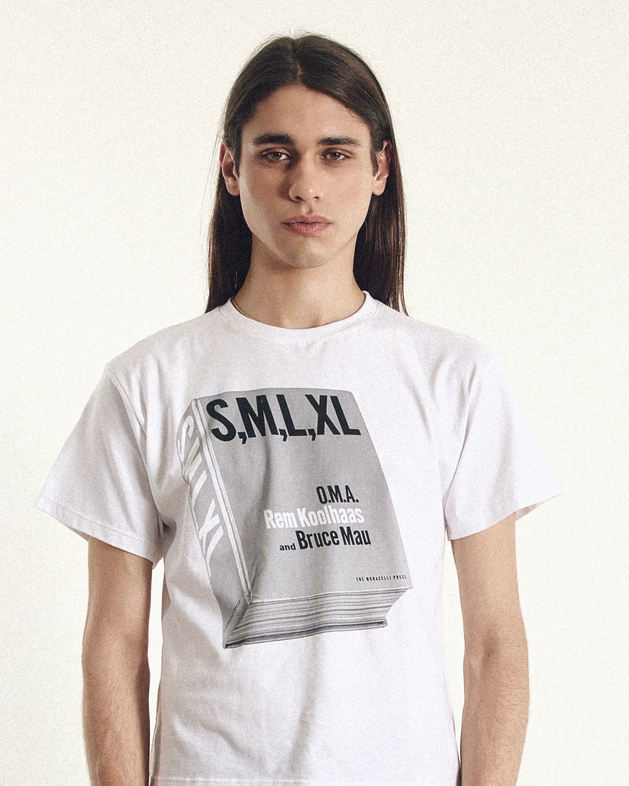 Person wearing a white t-shirt with graphic design and text on a plain background