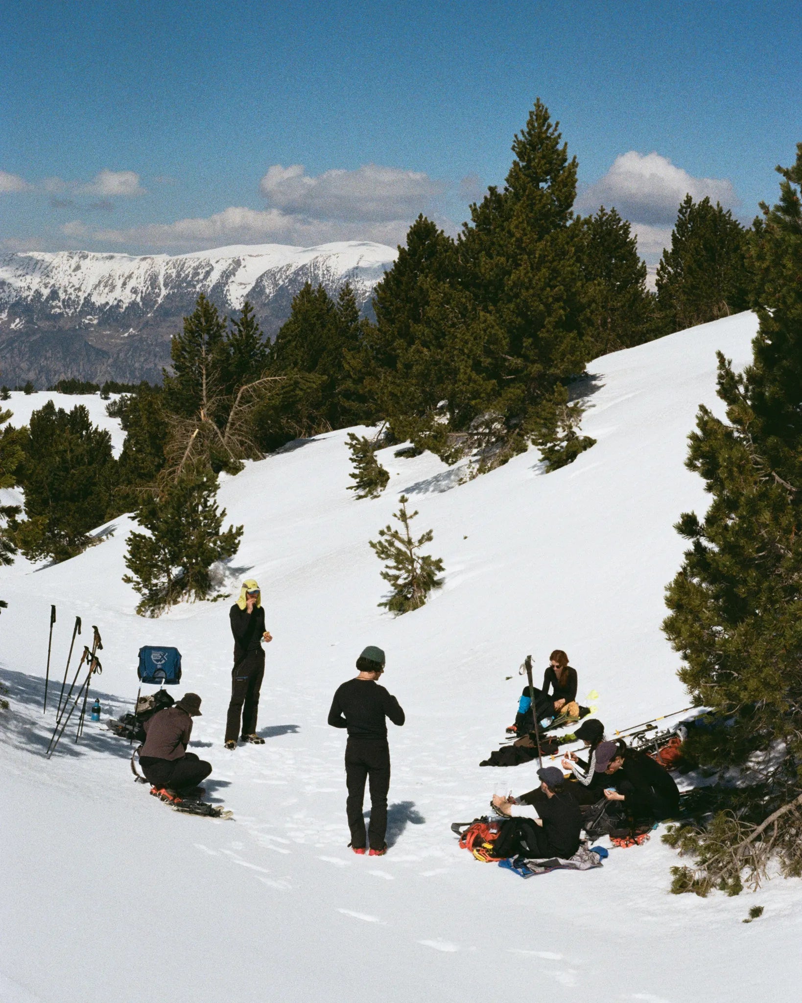 Group of people snowshoeing in a snowy landscape with mountains in the background