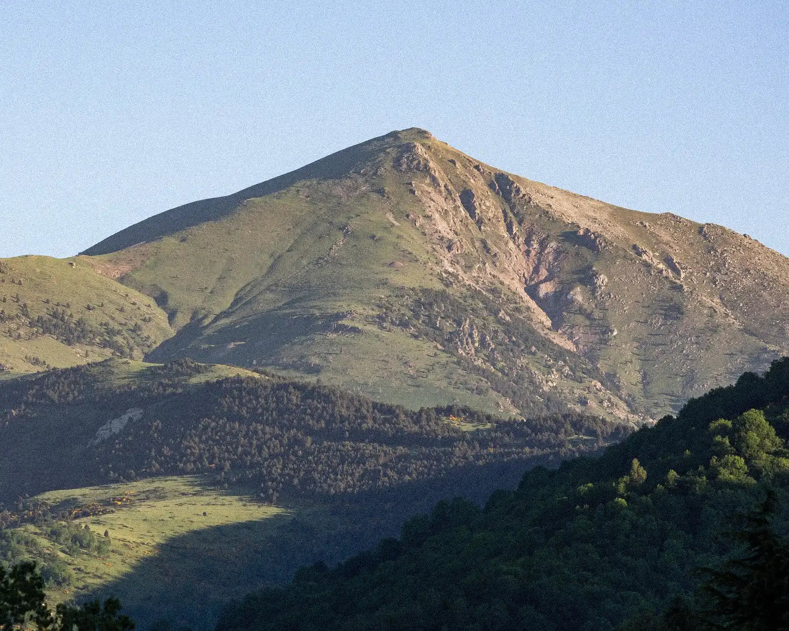 Mountain range with green slopes under a clear blue sky