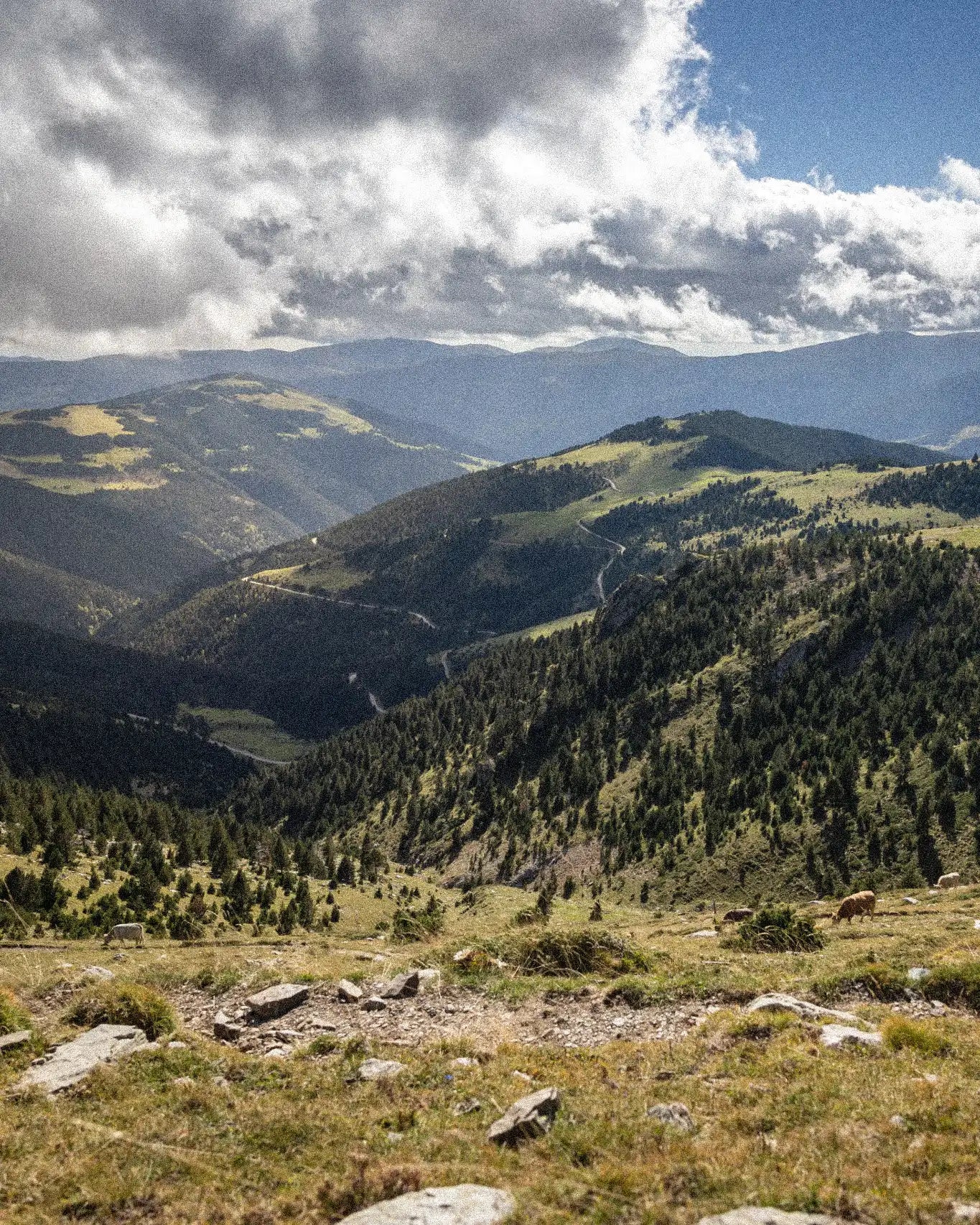 Scenic view of mountains with green valleys and a cloudy sky
