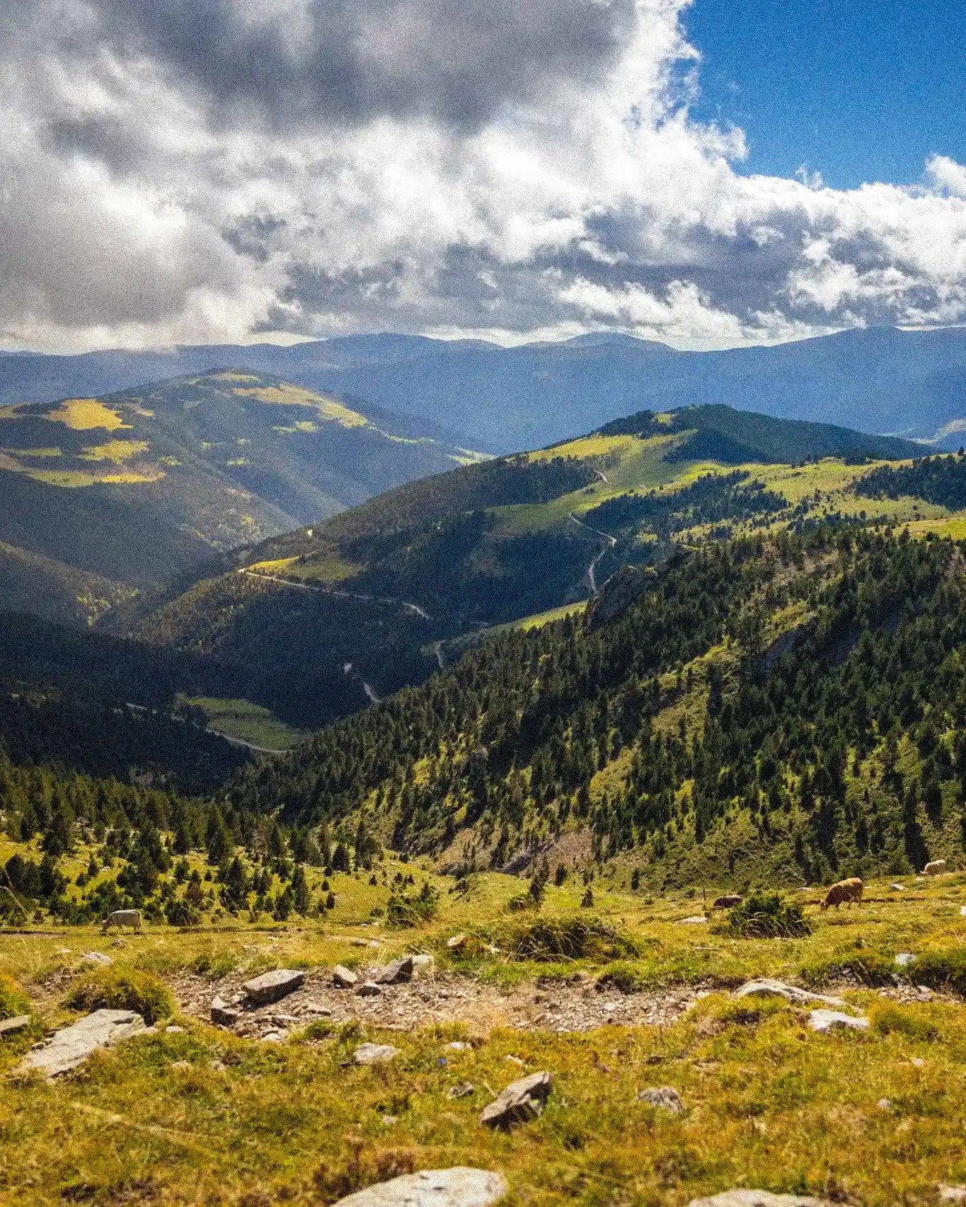 Scenic view of mountains with green valleys and a clear blue sky.