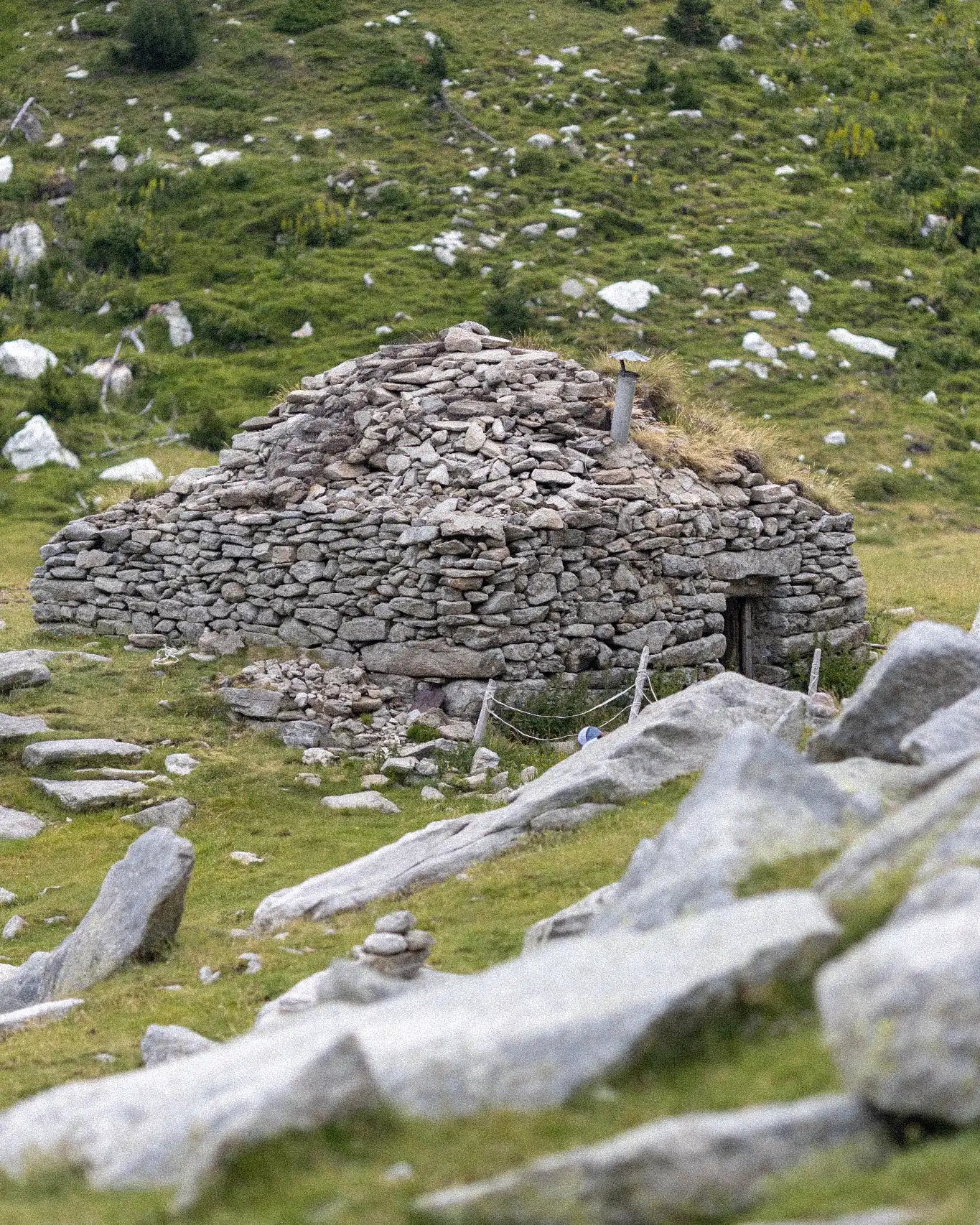 Stone structure in a grassy field with scattered rocks