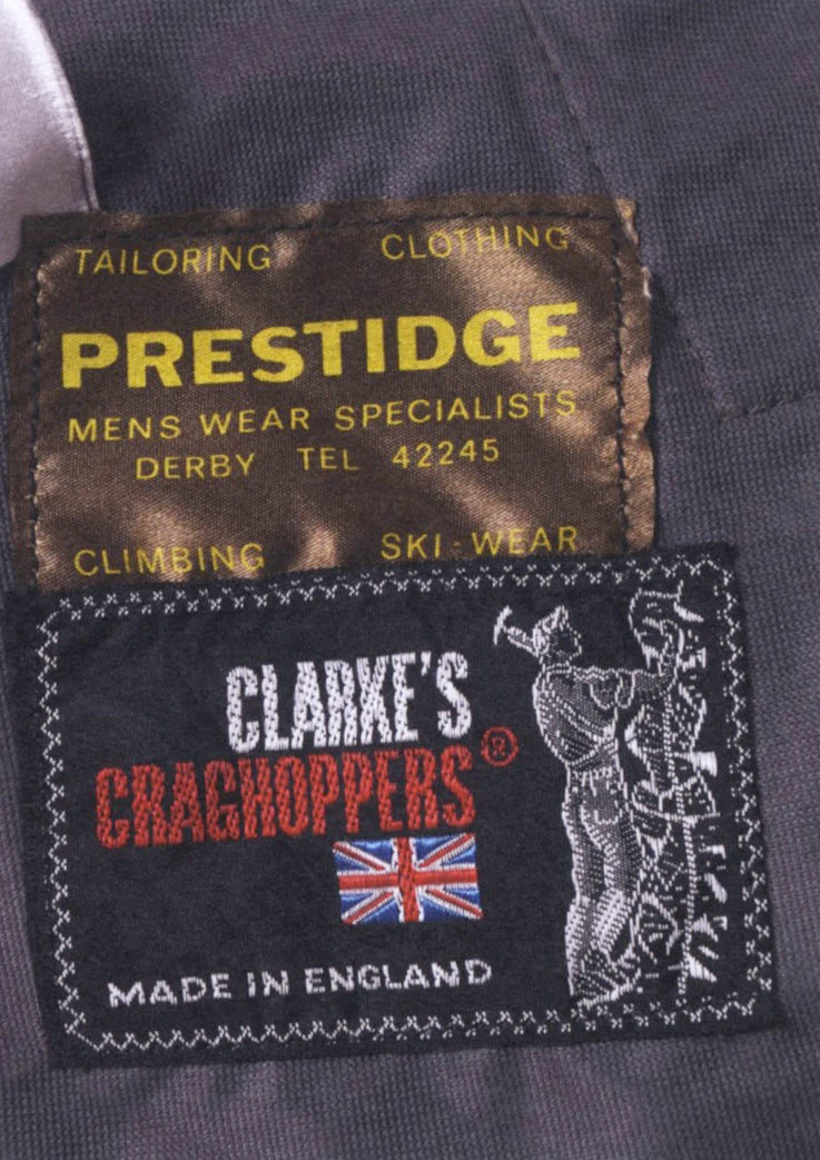 Clothing labels for Prestige and Clarke's Craghoppers on a dark fabric background