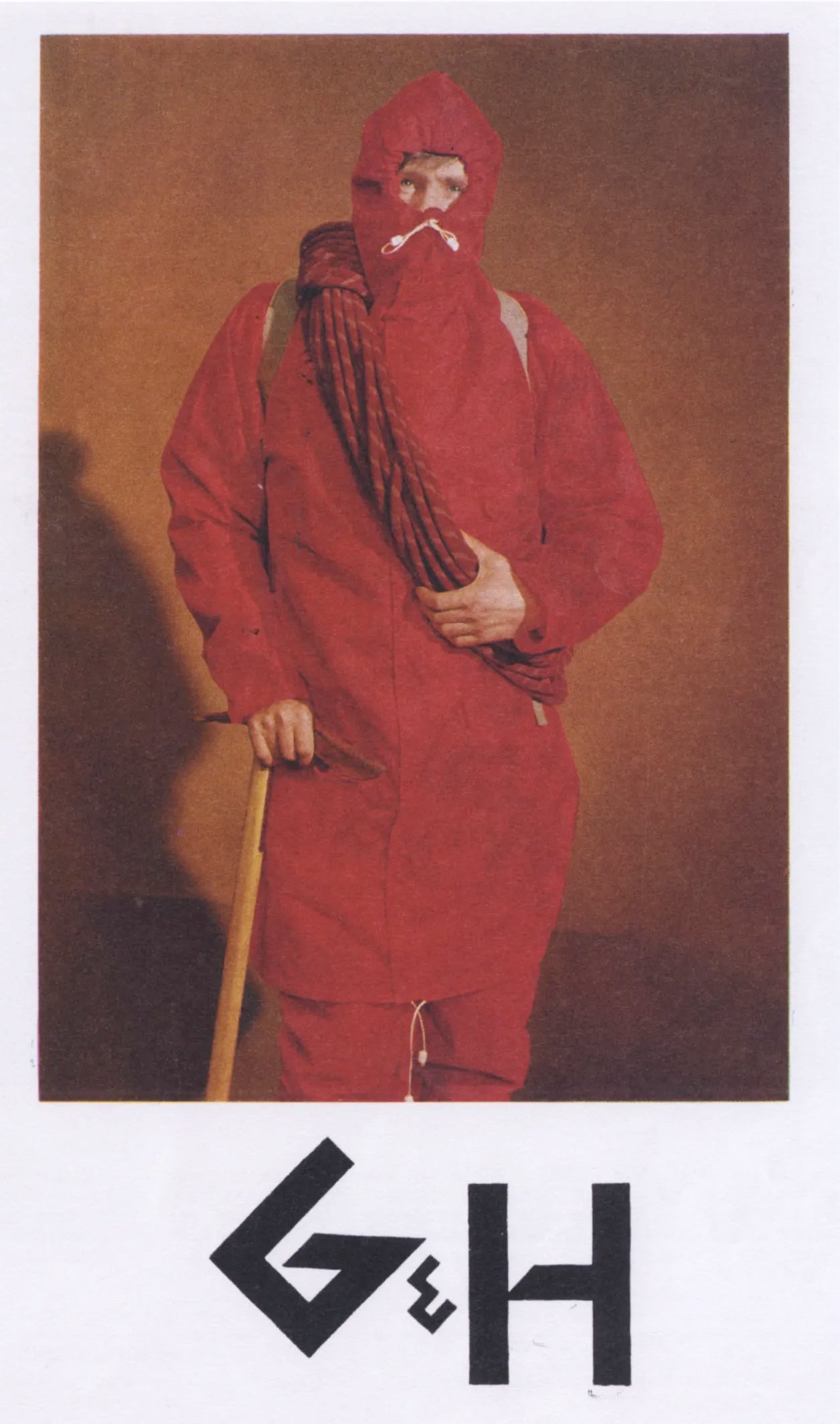 Person in a red protective suit holding a stick against a brown background with 'G&H' logo.