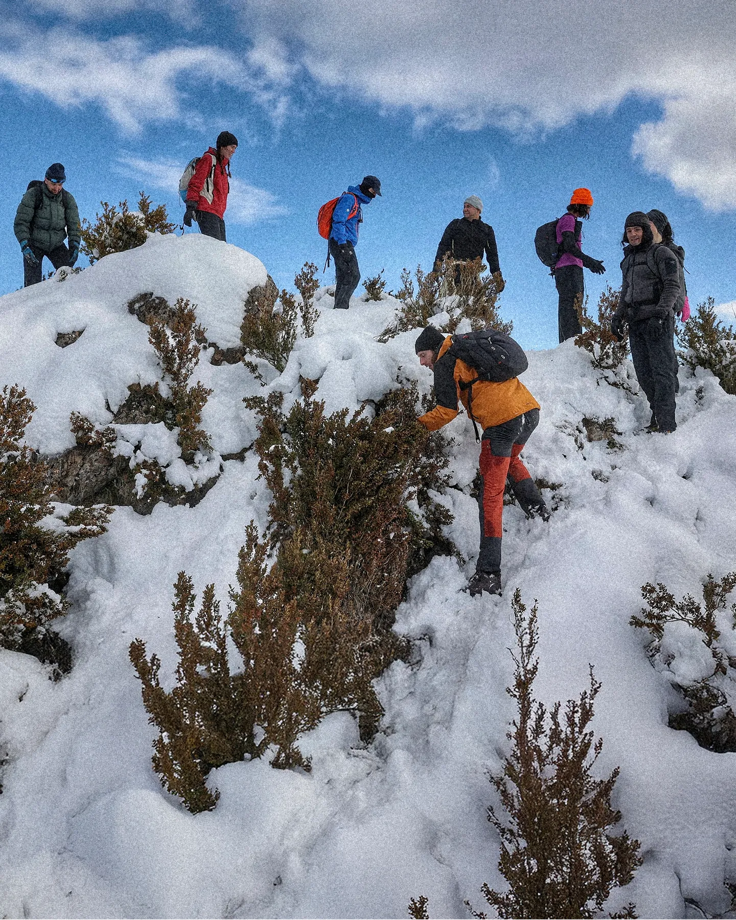 Group of people hiking on a snowy mountain with backpacks